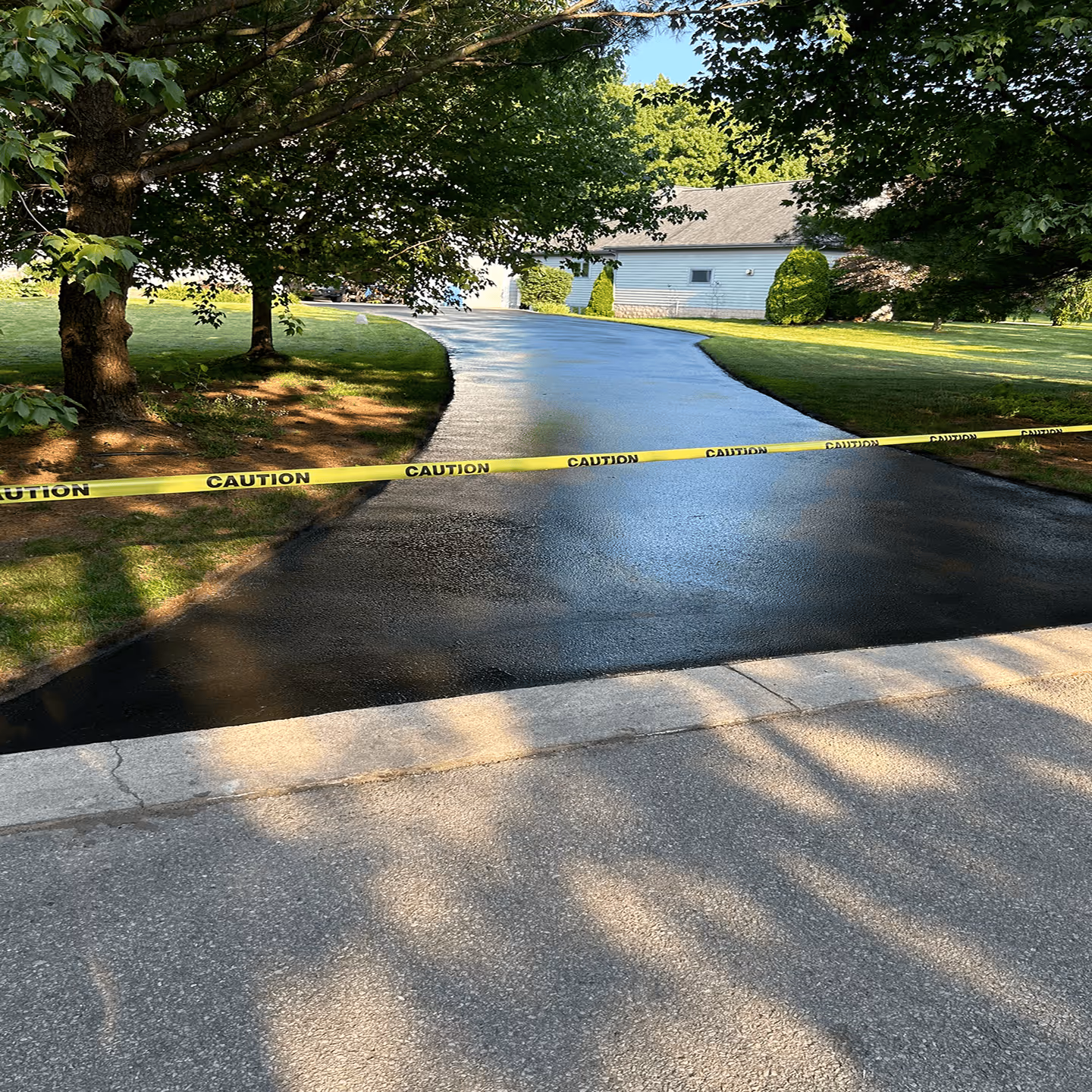 Premium asphalt sealant application for a large residential driveway in the Traverse City area.