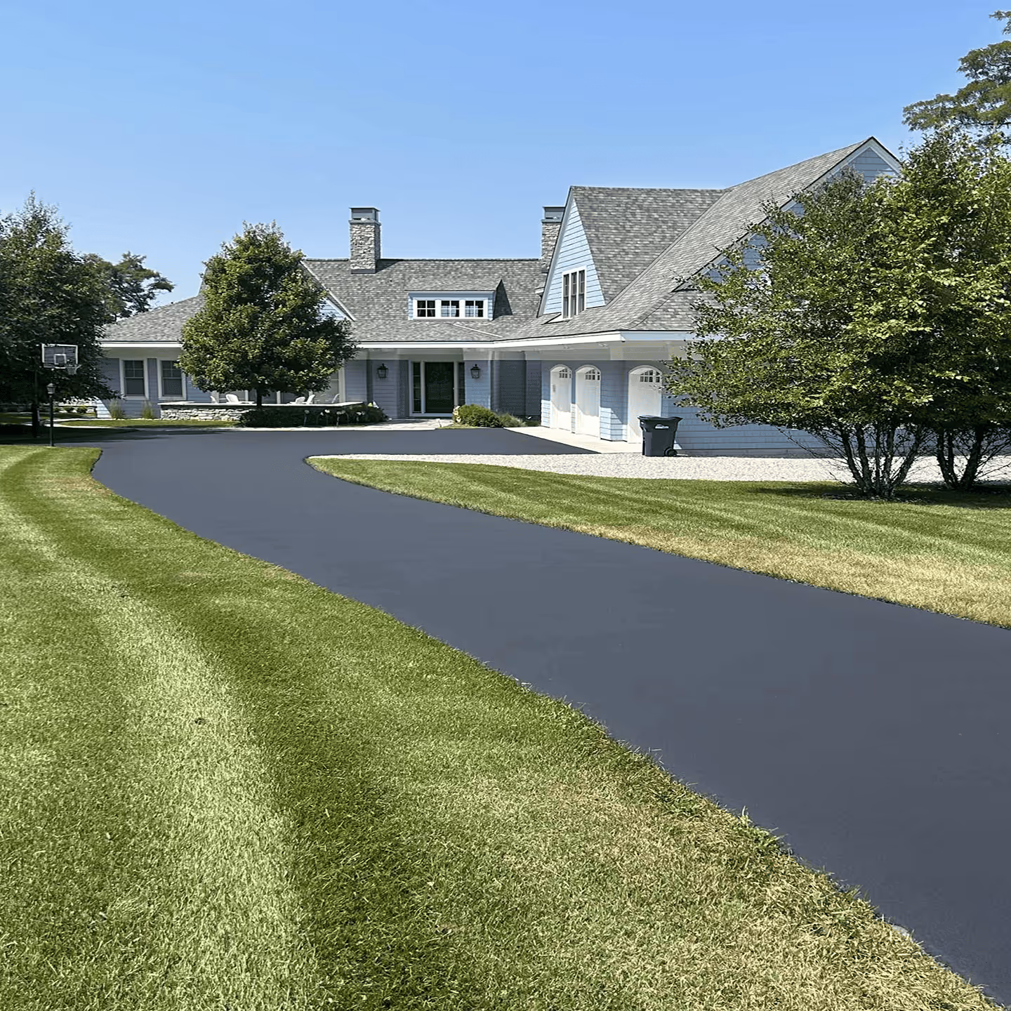Professional residential driveway sealcoating for a home in the village of Empire, Michigan.