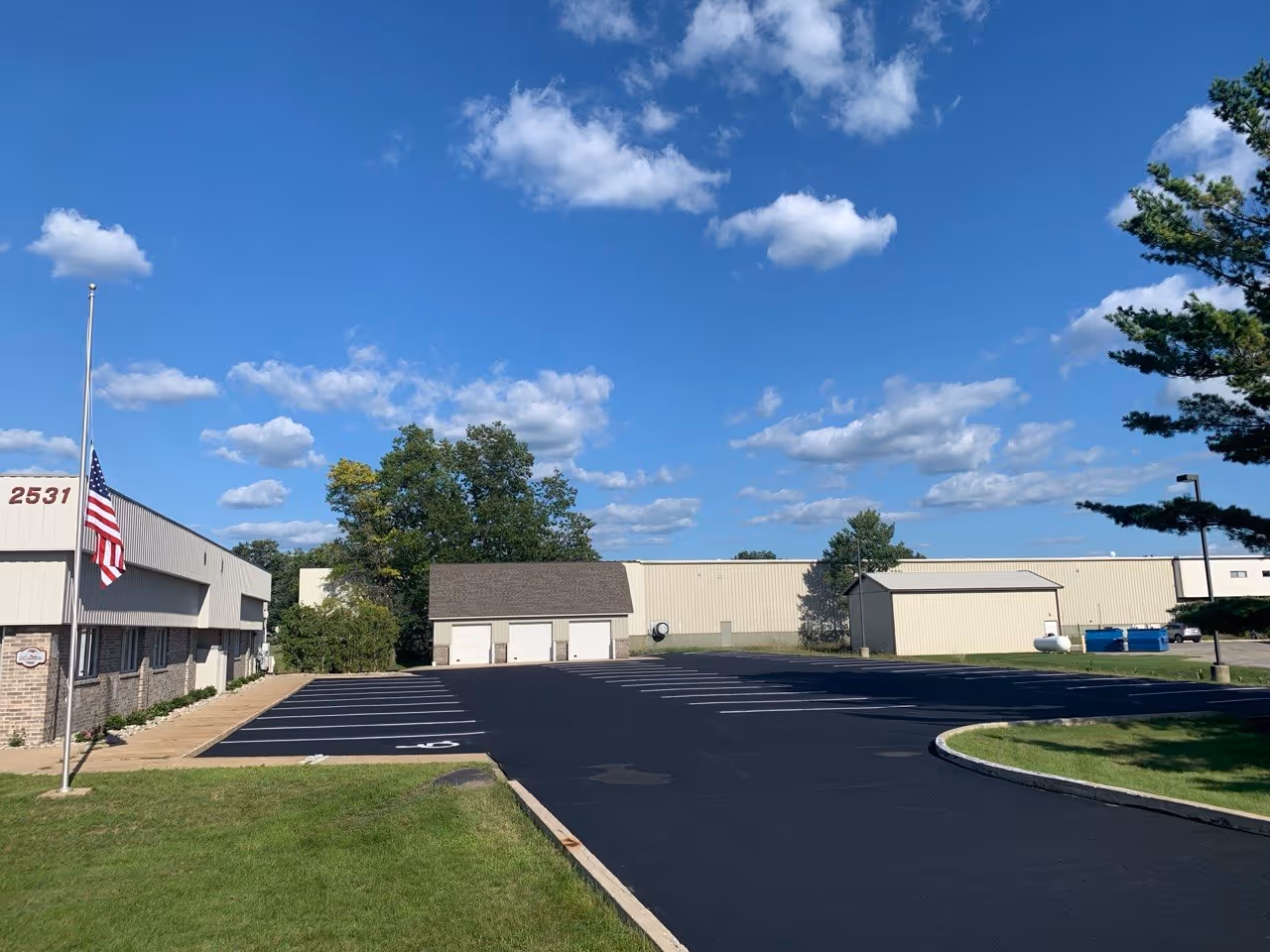 Commercial parking lot sealcoating and asphalt maintenance for NDX D.H. Baker on Aero-Park Dr in Traverse City, MI.