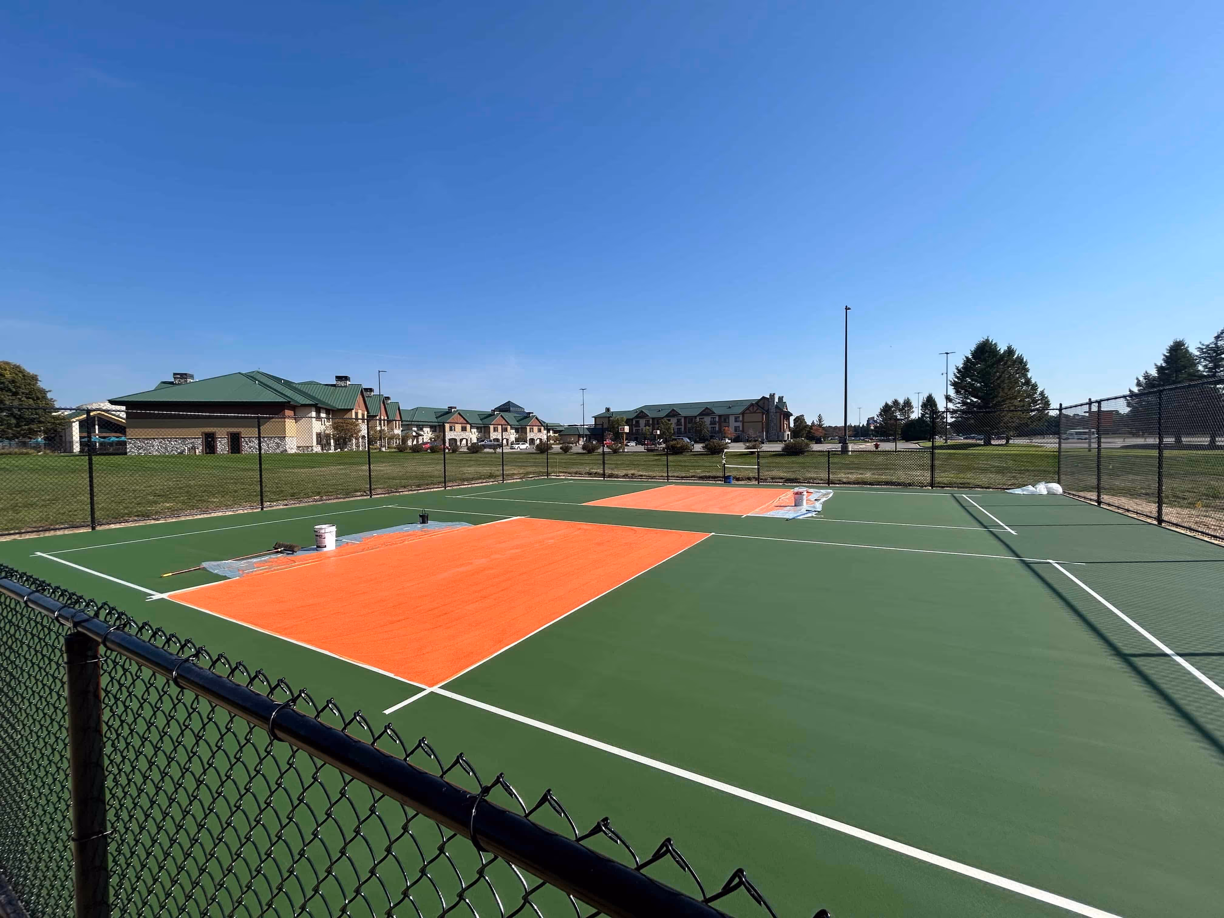 Meticulous layout and taping for professional pickleball court lines, ensuring exact specifications for the kitchen and boundary areas.