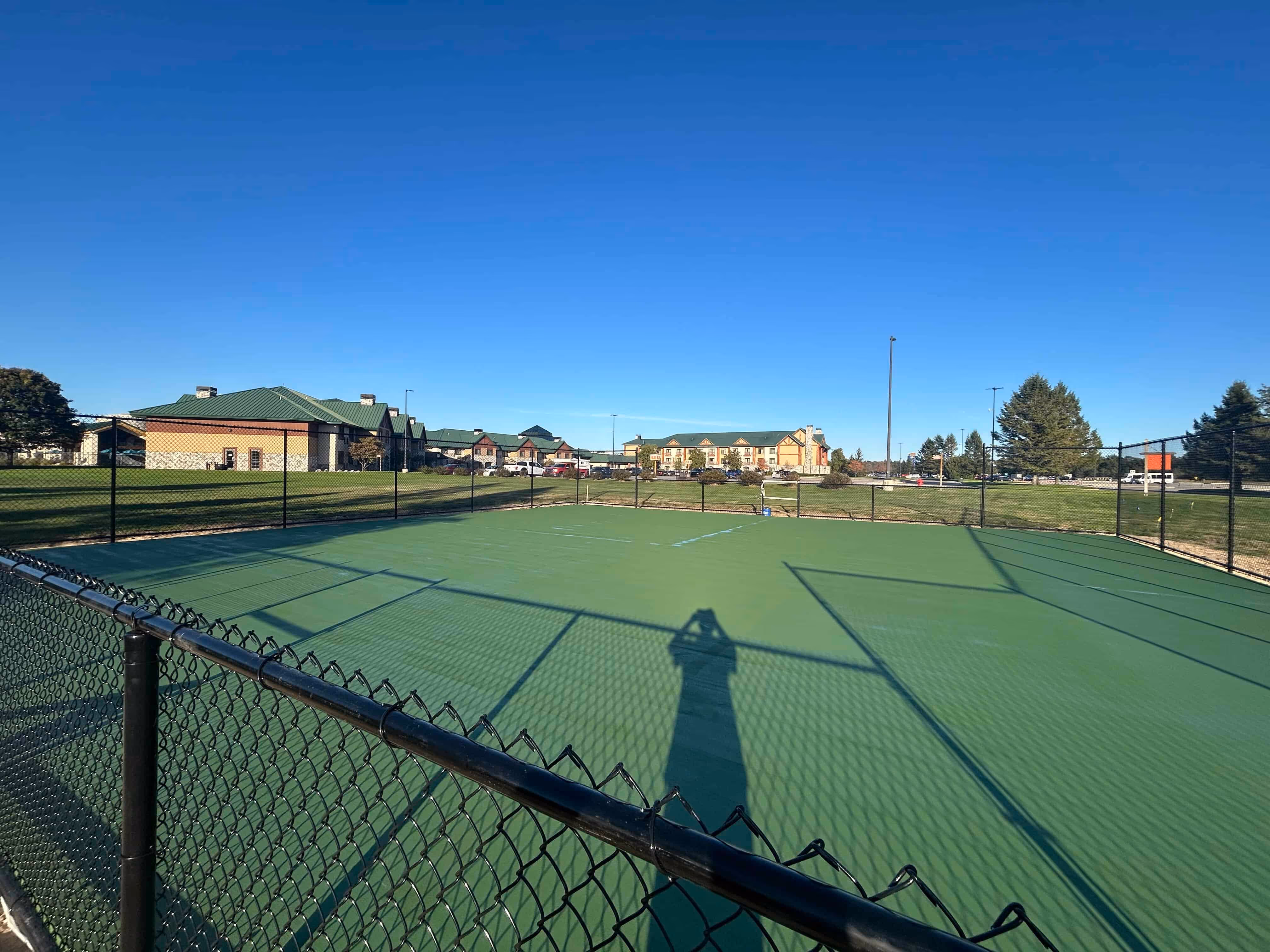 Application of the first textured acrylic color coating to a new pickleball court on Orchard Hwy in Manistee, MI.