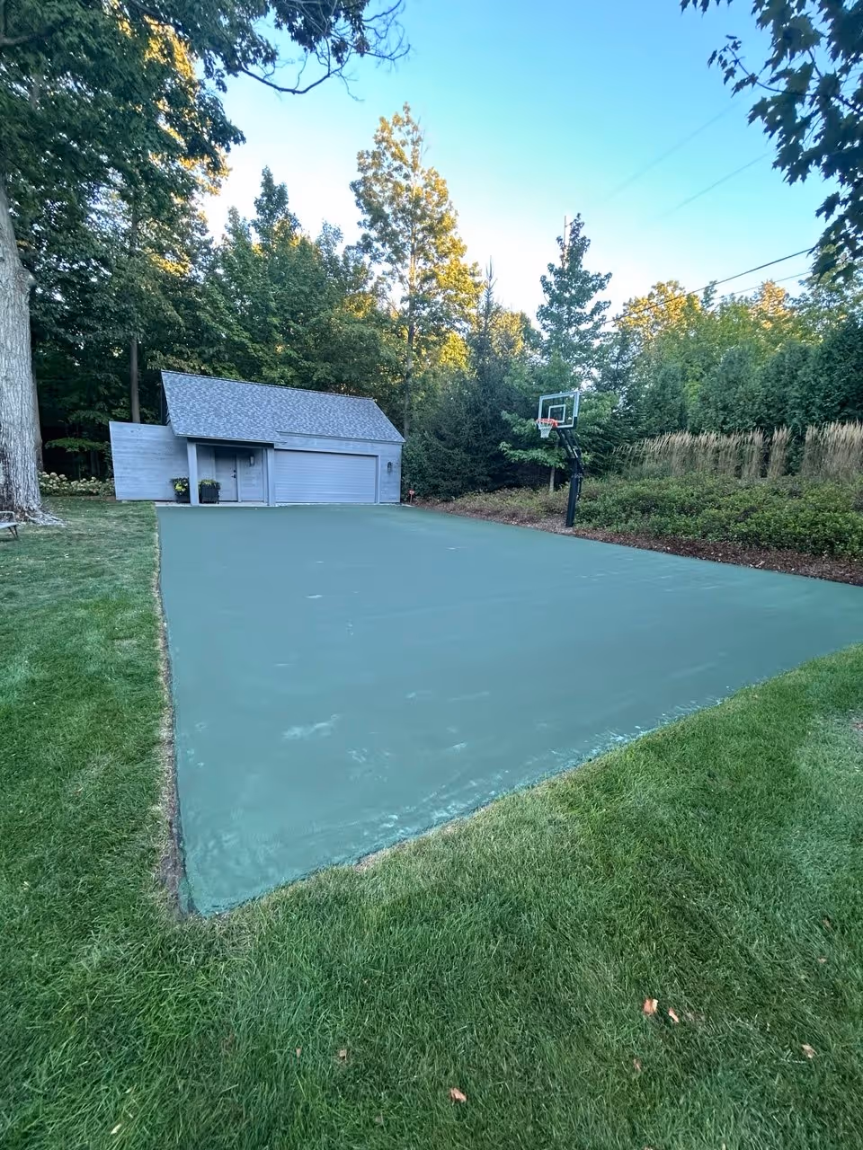 The fully dried, high-performance green acrylic surface on S Shore Dr, providing a consistent non-slip texture ready for the precision line striping phase.
