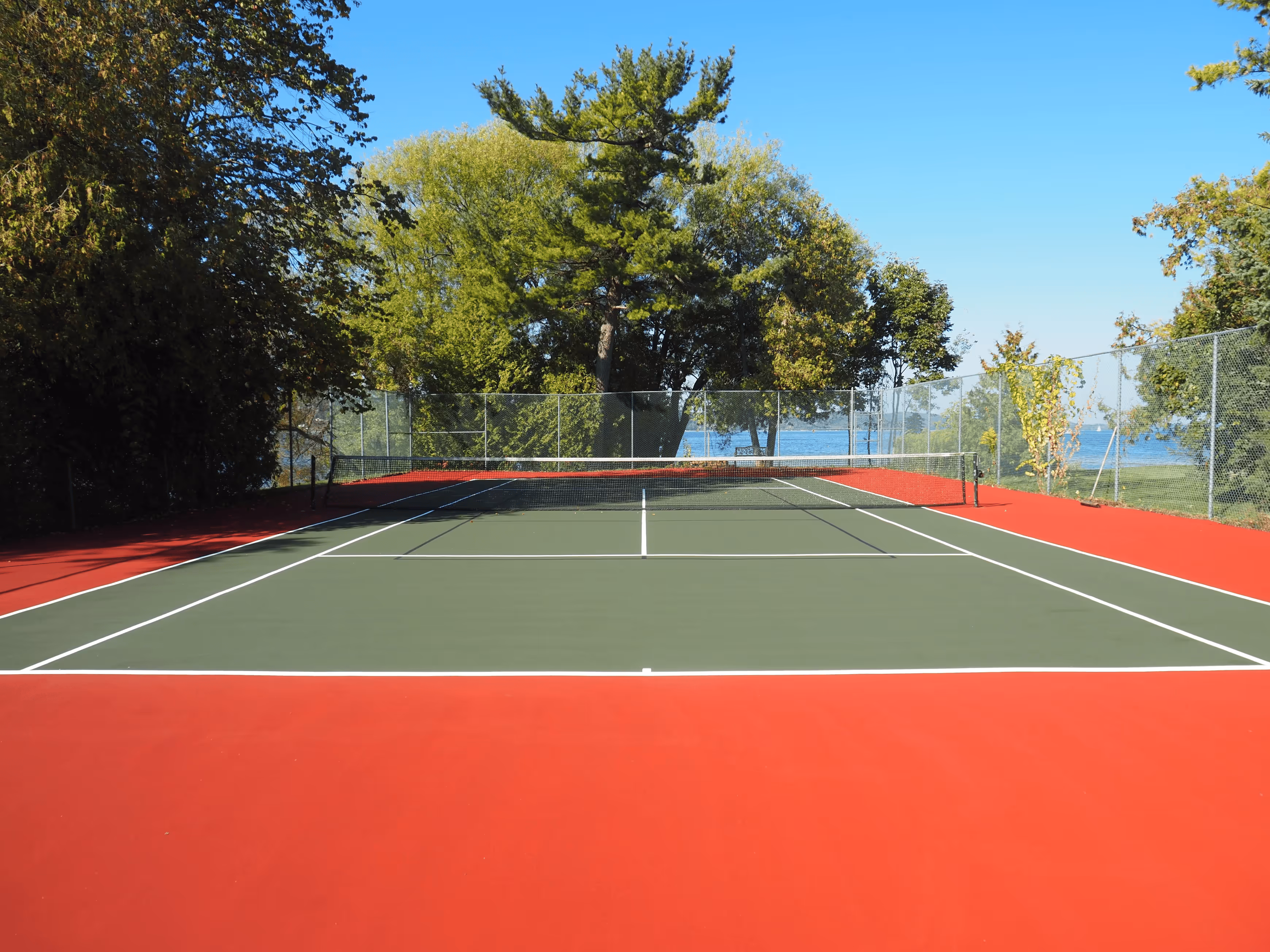 A top-down view of the completed multi-sport court featuring crisp white tennis lines and subtle black pickleball lines for a modern, aesthetically pleasing hybrid layout.