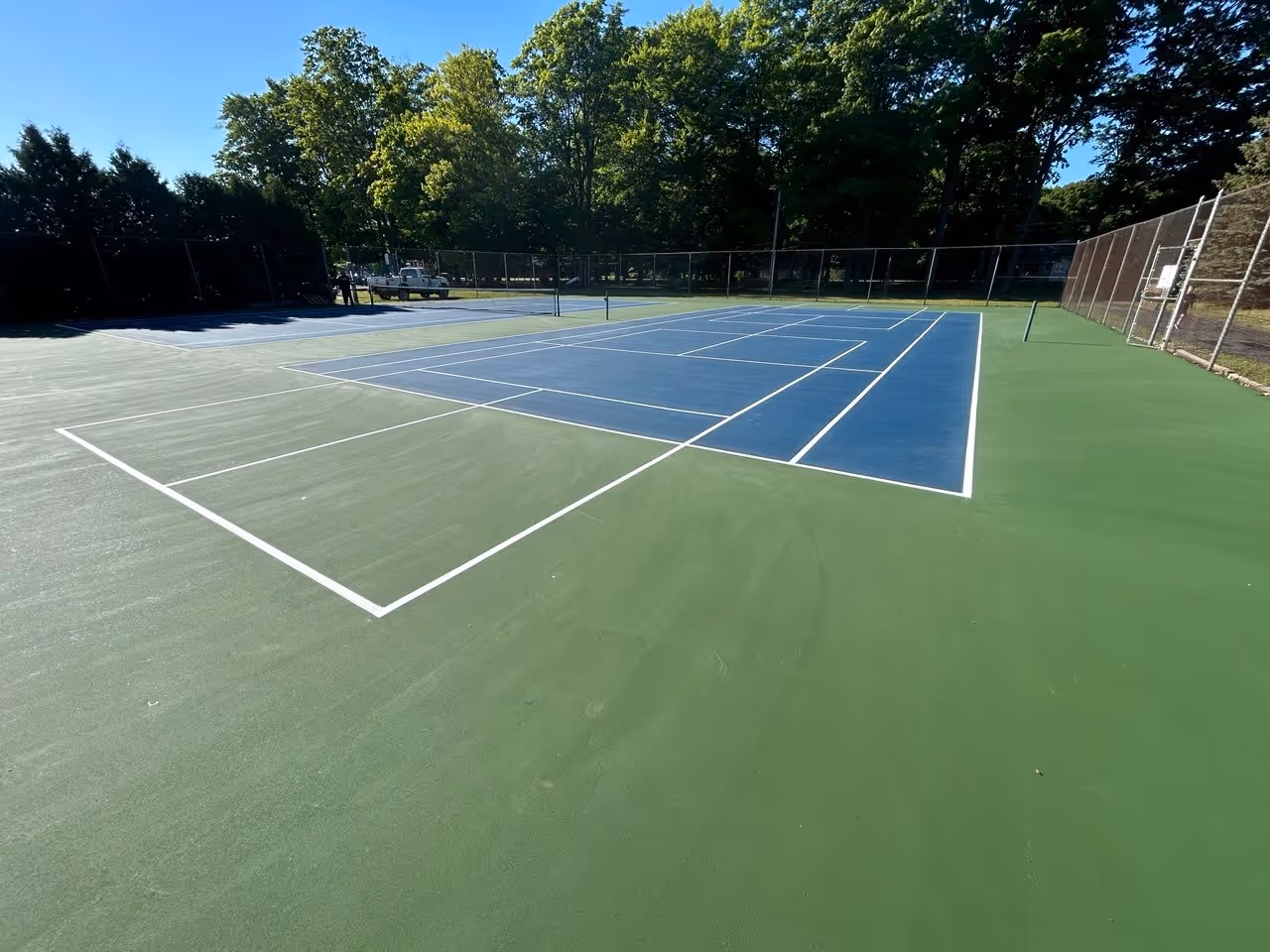 The completed multi-sport complex at Bowers Harbor Park in Traverse City, MI. This view shows the fully surfaced double tennis courts, featuring the additional pickleball courts professionally striped off the end of each tennis court for maximum recreational capacity.