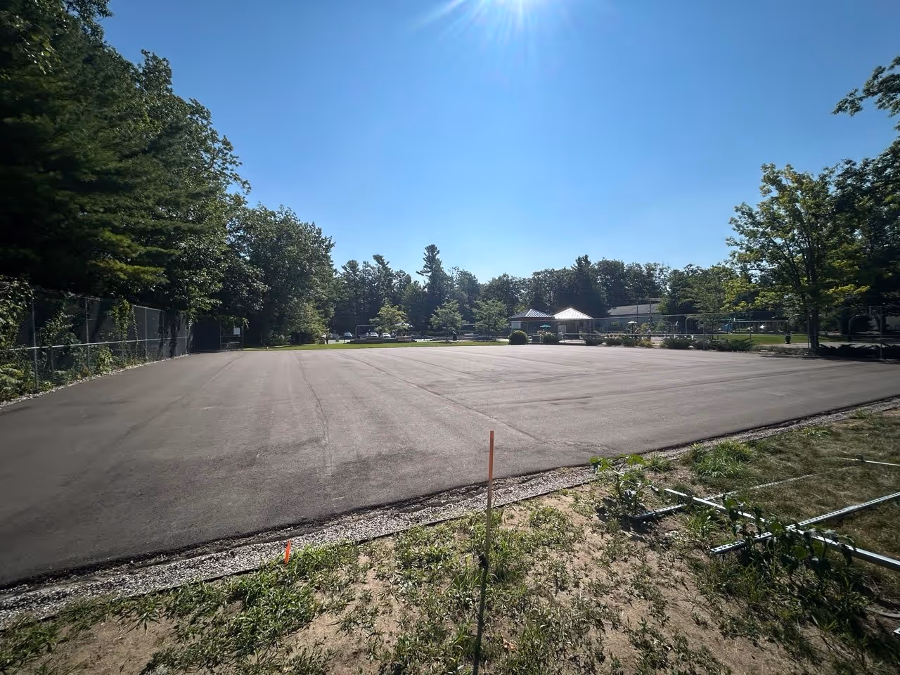 The new bare asphalt court footprint at Glen Arbor Township Park before the installation of net posts or the application of the professional surfacing system.