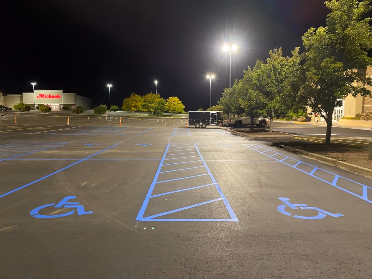 A new commercial parking lot layout and precision line striping at the Michaels retail location on N US-31 S in Traverse City, MI. This project was completed for Countrywide Paving & Concrete, highlighting high-visibility pavement markings and professional traffic organization for a high-traffic national retail brand.
