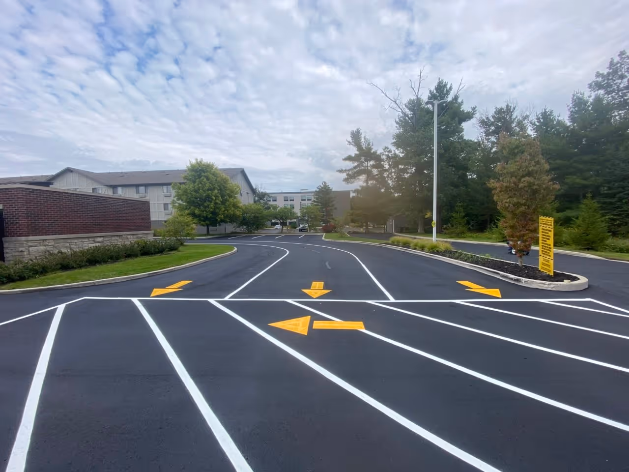 A freshly sealcoated and re-striped parking lot at the Green Mitt Car Wash on US-31 in Traverse City, MI. The deep black sealant provides a sharp contrast for the new white parking lines and directional markings, ensuring a professional and clean appearance for this high-traffic local business.