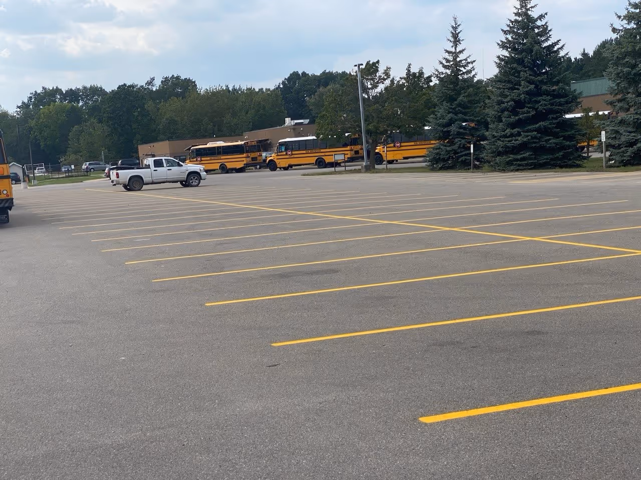 Professional restriping of high-visibility yellow parking lines at the North Ed Career Tech campus and Dean Transportation facility on Parsons Rd in Traverse City, MI. The project ensures safe traffic flow and organized bus parking for the Northwest Education Services regional center.