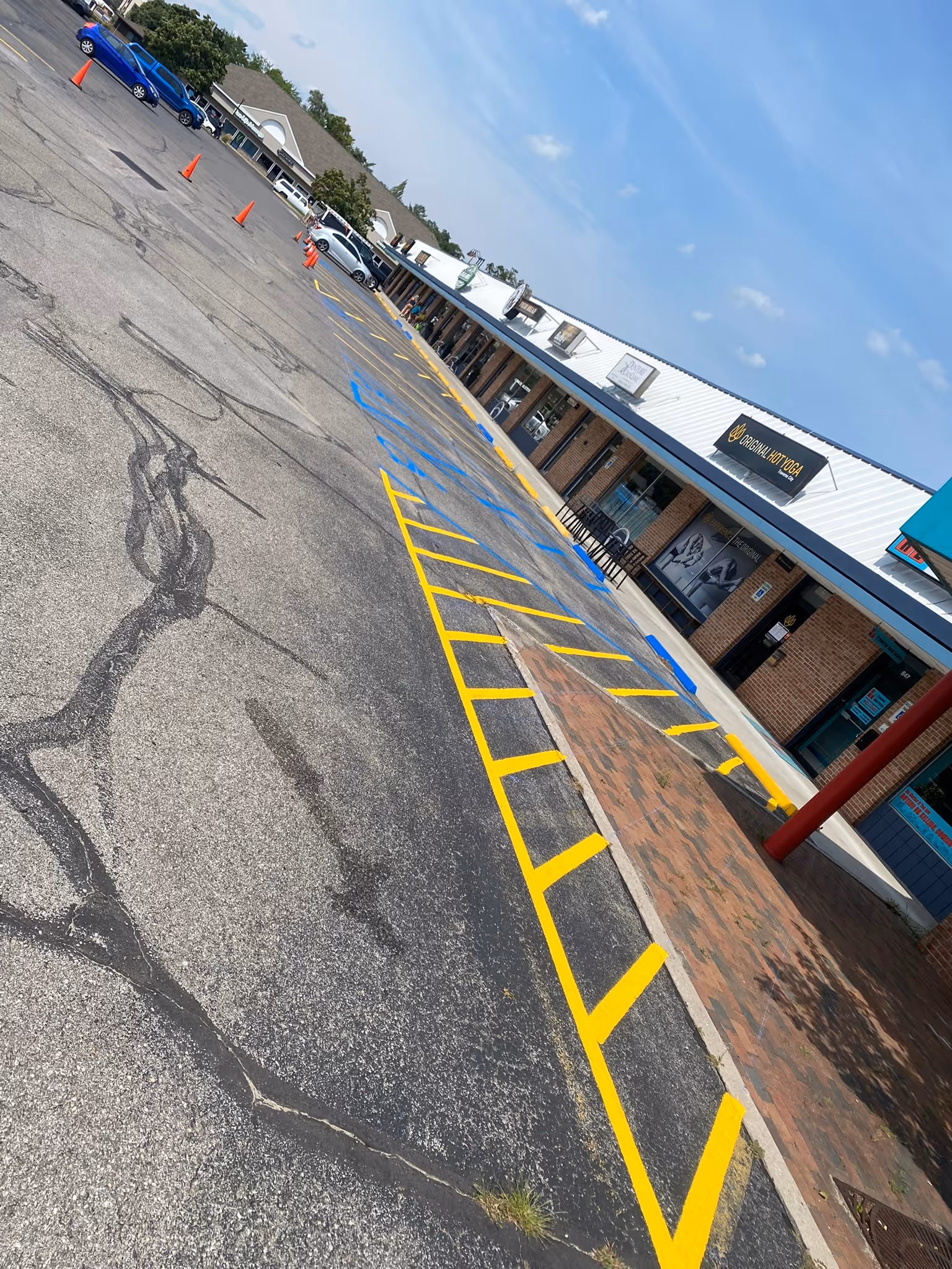 Professional parking lot restriping for a multi-business commercial complex in Traverse City, MI. The image showcases freshly painted, high-visibility white lines and stalls, specifically designed to optimize traffic flow and organized customer parking for a high-traffic, multi-tenant property.
