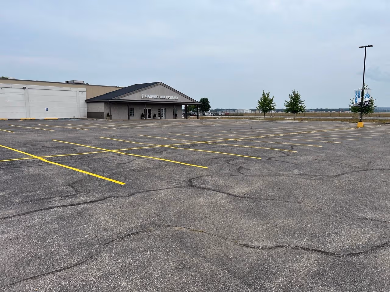 Professional parking lot restriping featuring crisp white lines at Harvest Church on Garfield Ave in Traverse City, MI. The project ensures organized high-capacity parking and safe traffic flow for the church's main entrance and community facilities.