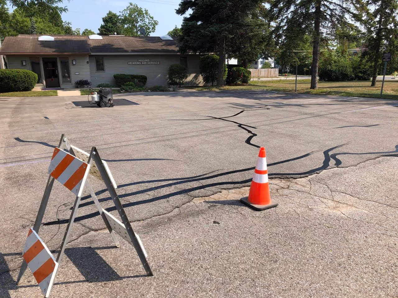 The entire parking lot at Higgins Hearing and Audiology after comprehensive crack sealing. This stage shows the pavement fully prepped and cleaned for the upcoming sealcoating application.