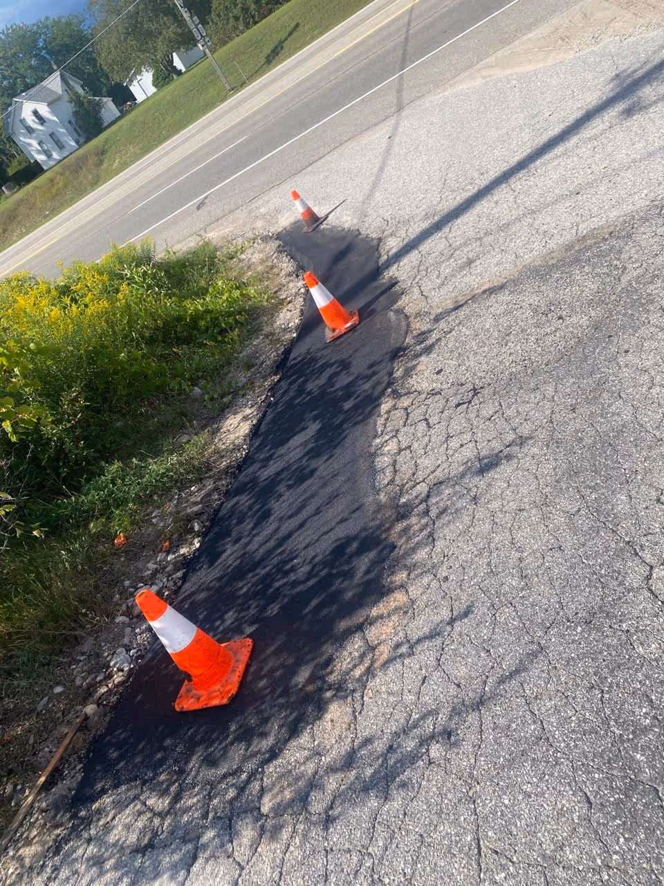 A hybrid commercial asphalt repair at the AT&T shop entrance on Hastings St in Traverse City, MI. The project utilizes a combination of cut and replace for structural integrity and infrared heating to seamlessly blend the new asphalt edge into the existing pavement, eliminating joints and preventing future edge failure.