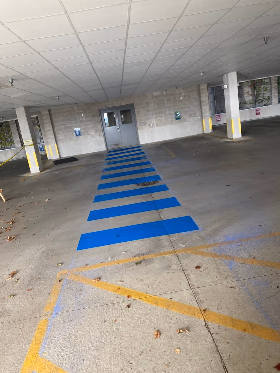 ADA-compliant blue handicap parking stalls and safety crosswalk striping for Thirlby Clinic, PLC in the Copper Ridge parking garage, Traverse City, MI.