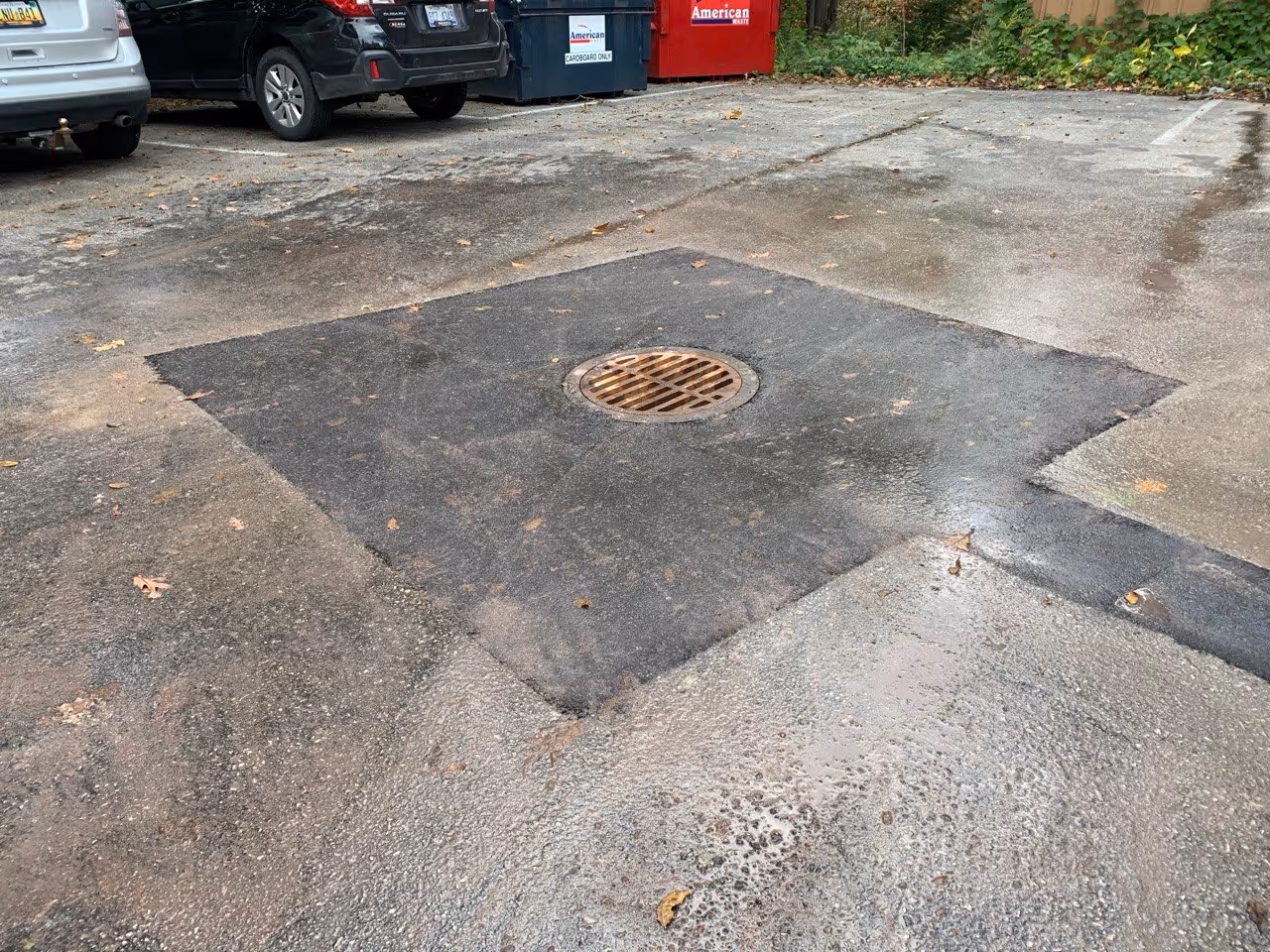 A new catch basin drain and smooth, compacted asphalt with a precision slope for water drainage at Cottonseed Apparel on Western Avenue in Glen Arbor, MI.