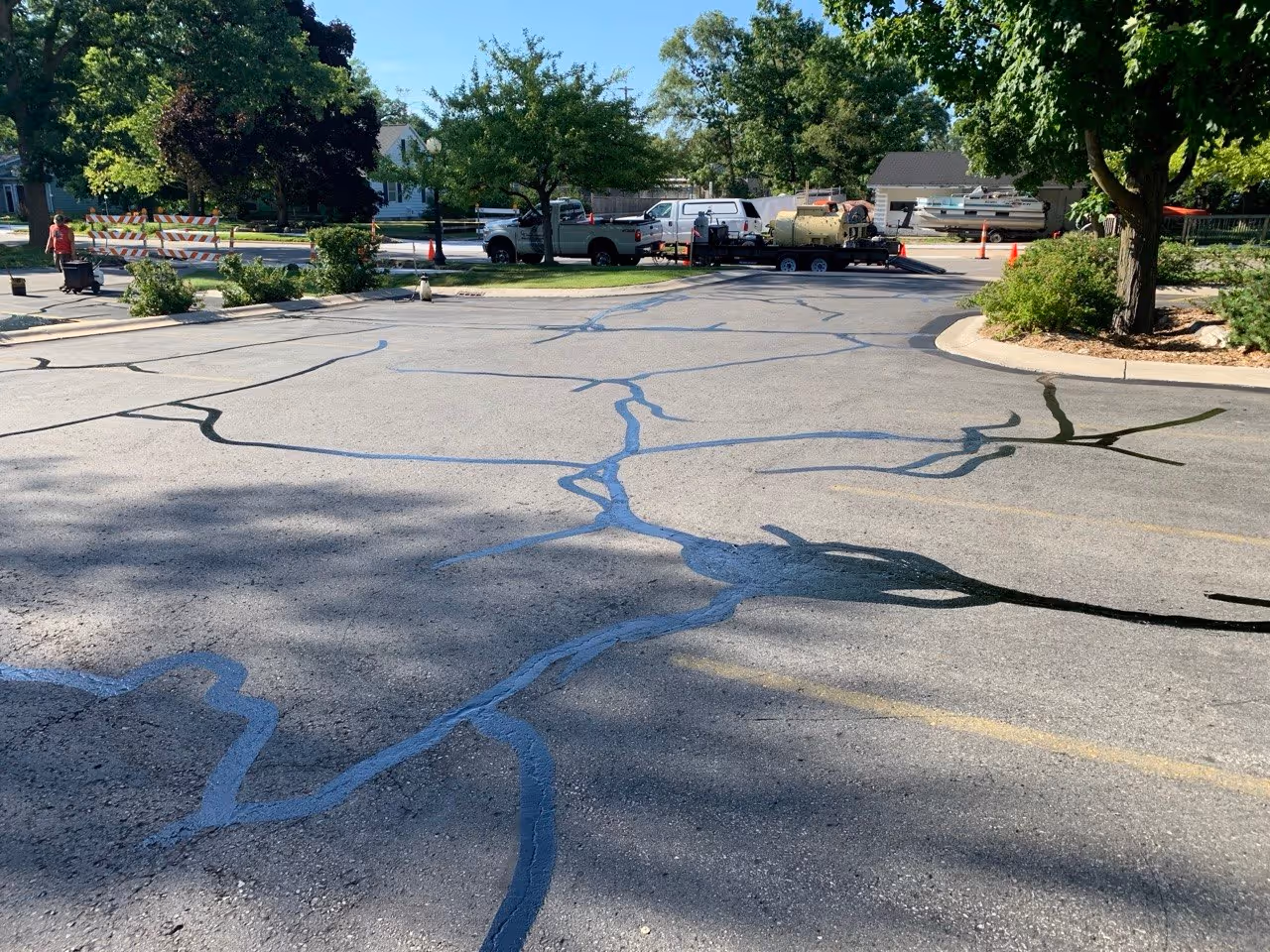 A freshly crack-sealed commercial parking lot at Soave Eye Care on S Garfield Ave in Traverse City, MI, showing the completed hot-rubberized asphalt repairs prepped and ready for a professional sealcoating application.