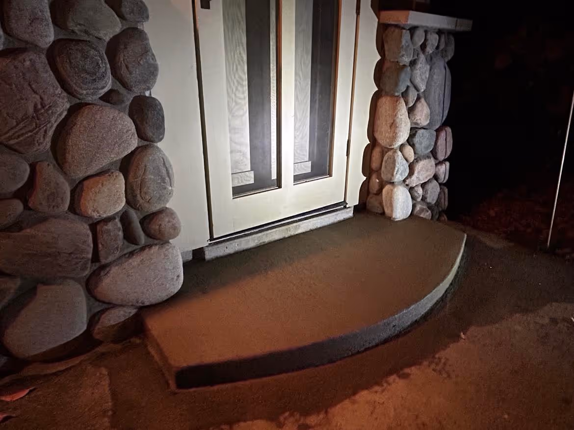 The completed concrete step replacement at a Big Glen Lake residence off S Dunns Farm Rd, near The Foothills Cafe & Motel. The new step is poured and finished for long-term durability against Michigan winters.