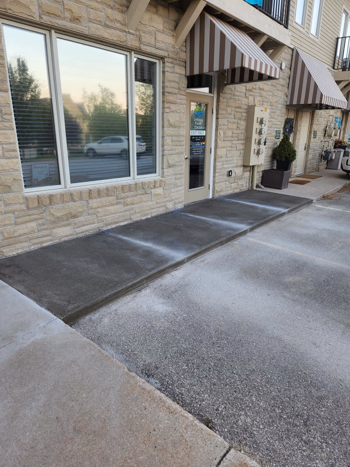 A completed commercial concrete sidewalk in Suttons Bay, MI, on the corner of M-22 and Summerset Ct. The concrete is cured with form boards removed and precise relief cuts made.