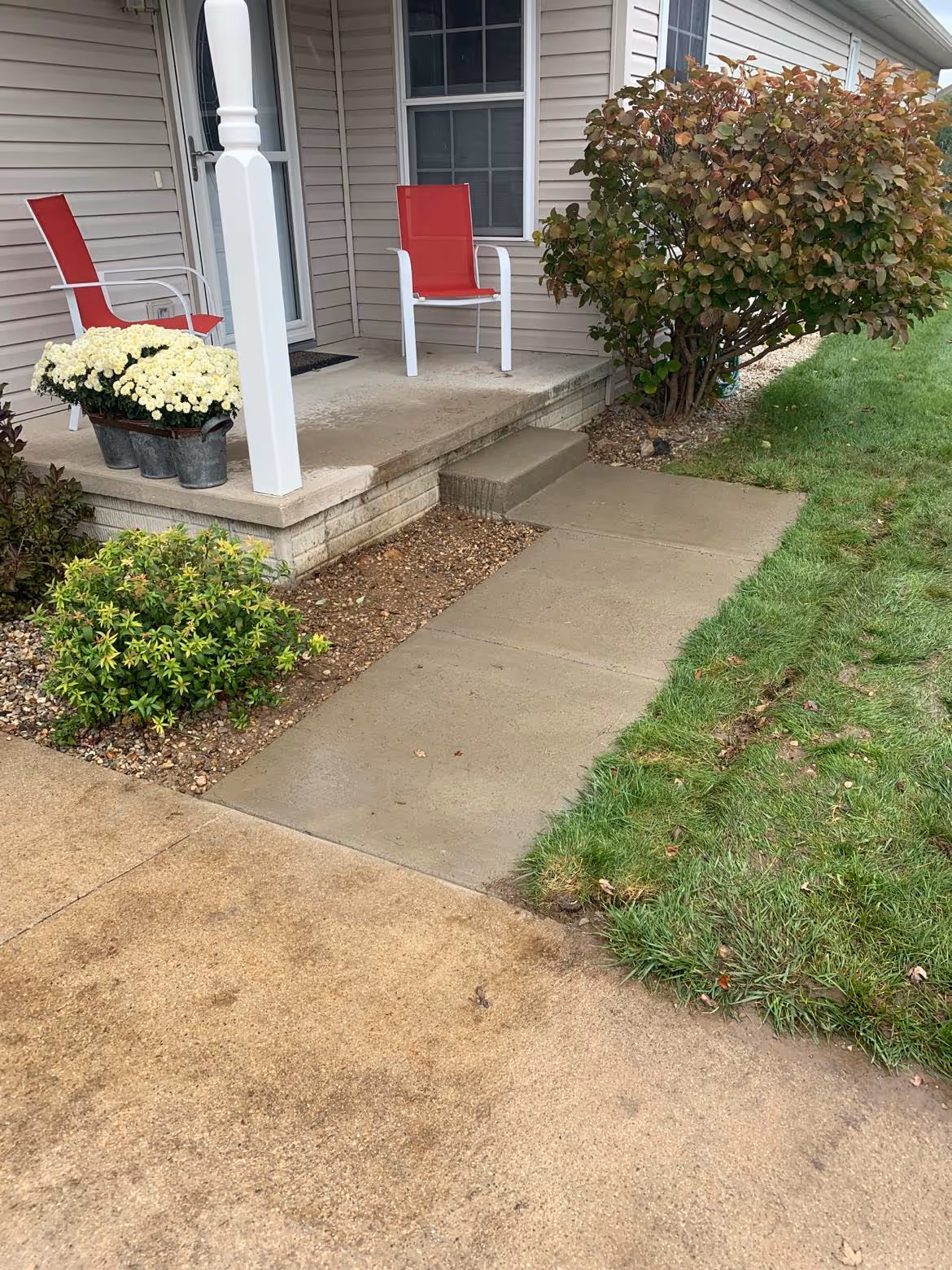 Newly replaced concrete sidewalk and front step at a Schmidt Rogers managed HOA in Traverse City. The invasive bush was removed to prevent future root damage and ensure a level, ADA-compliant walkway.