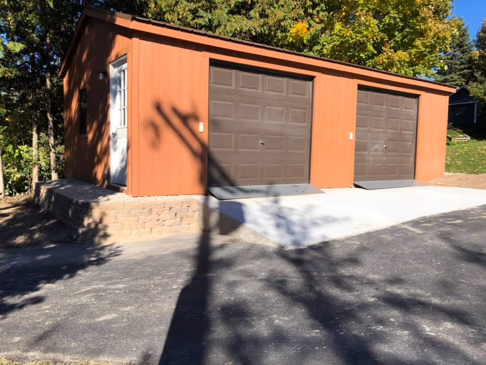 Completed concrete ramp, garage apron, and integrated retaining wall securing the portable garage foundation at S Lakeview Rd and E Lakeview Hills Rd.