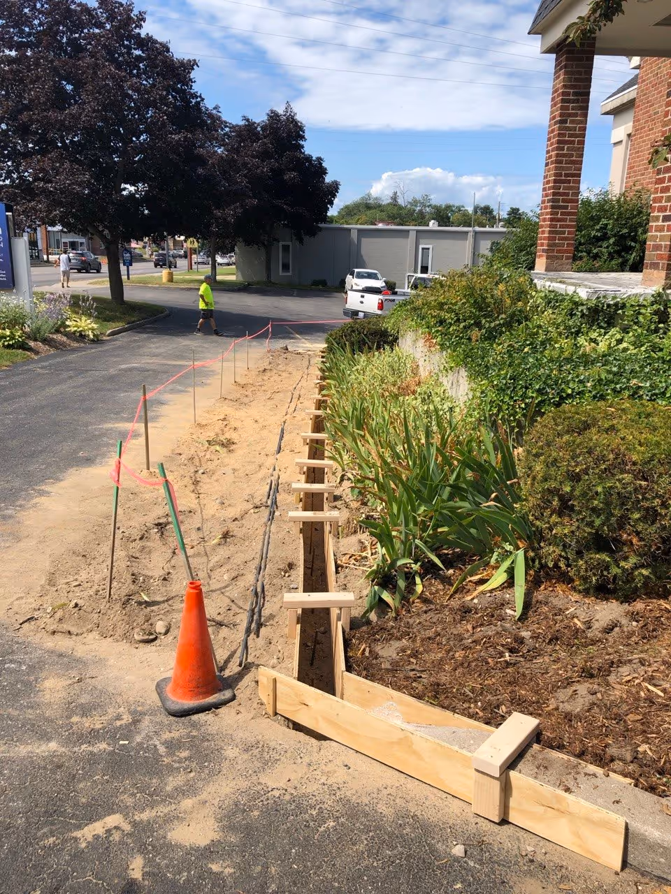 Wooden concrete curb forms installed and ready for a pour at the high-traffic intersection of E Front St and S Garfield Ave.