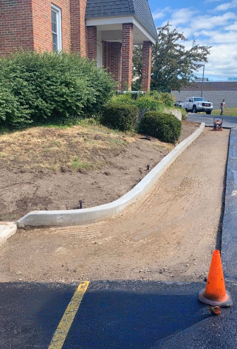 Preparing the asphalt surface for patching next to new curbing, featuring a clean saw-cut edge to ensure a seamless transition and long-term durability.