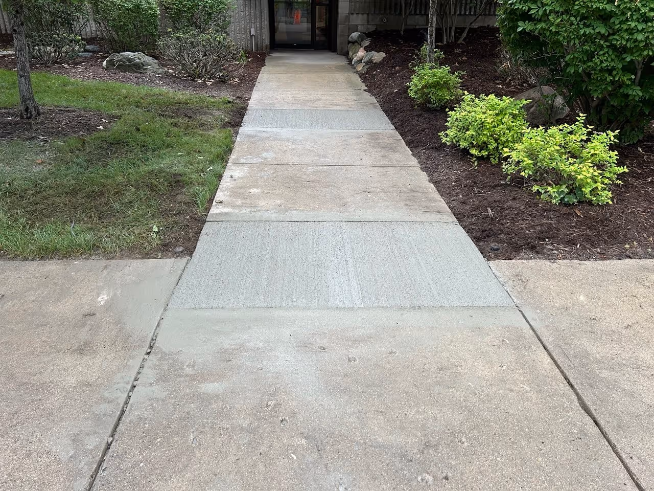Cleaned and cured concrete sidewalk sections restoring safe pedestrian access at VP Demand Creations on Aero-Park Drive.