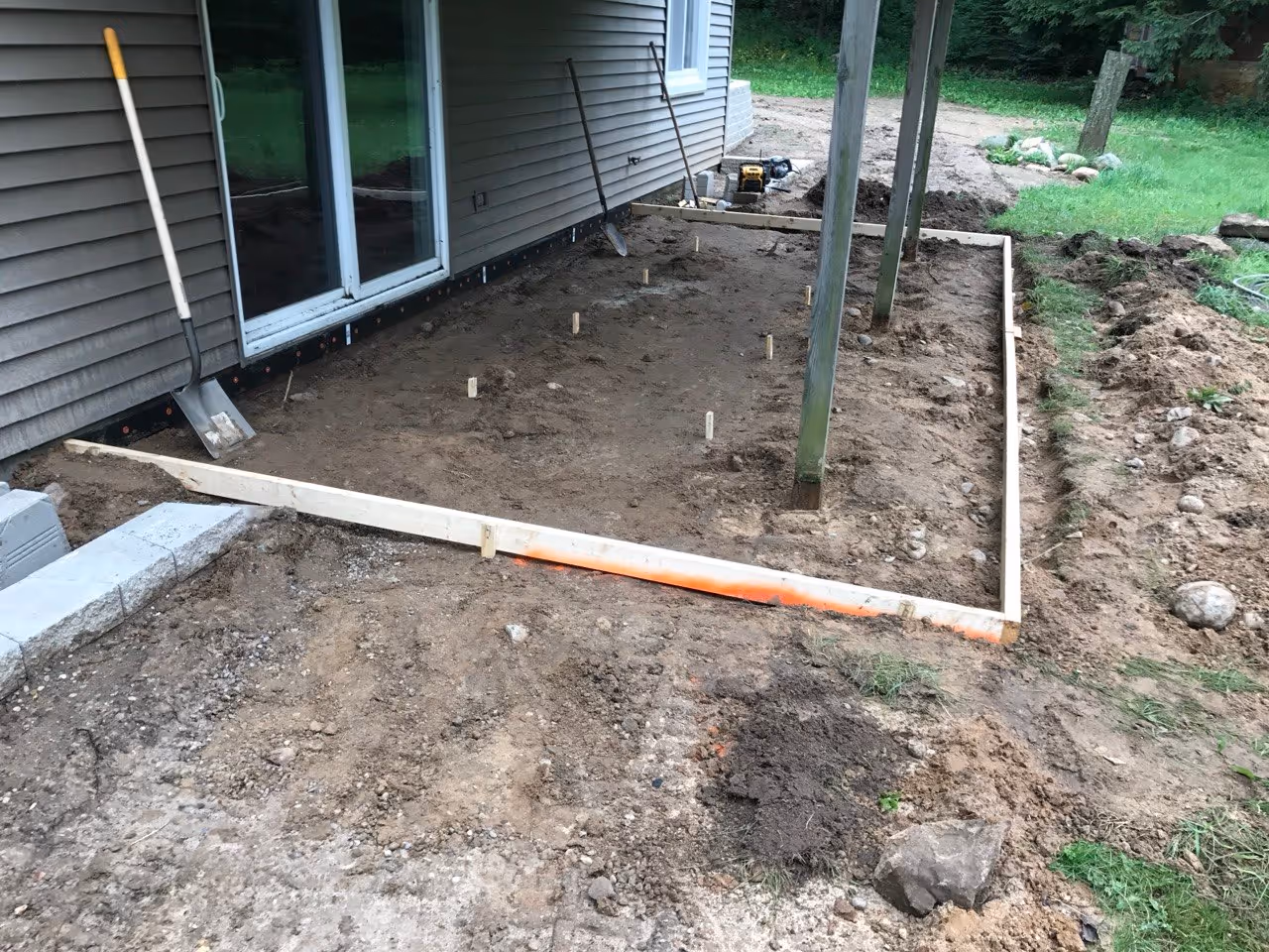 An excavated and formed area on S Coleman Rd prepped for a new residential concrete patio, showing the sub-base and wooden forms ready for the pour.