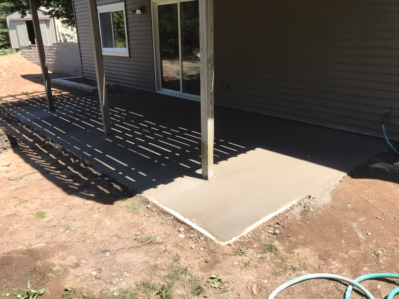 Freshly poured concrete for a new backyard patio at a private residence outside Maple City, Michigan.