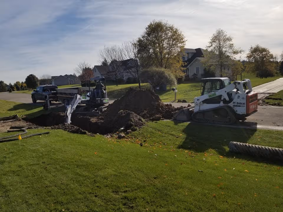 Excavating a collapsed metal drainage pipe in South Creek; removing the failed infrastructure to solve localized flooding and prevent further driveway washout.