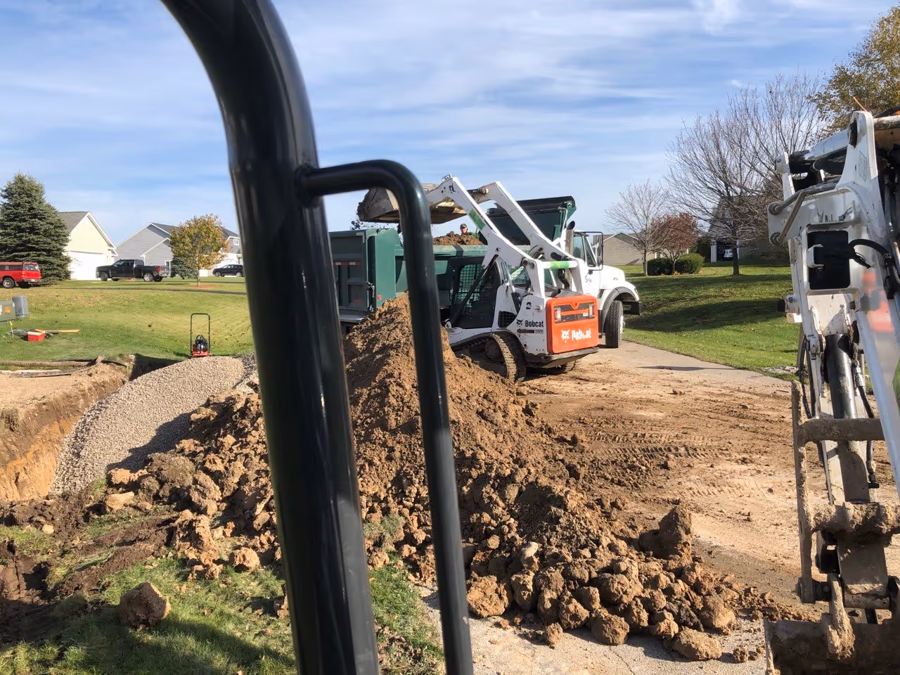 A dump truck backfilling a newly installed driveway culvert with stone in South Creek, ensuring the pipe is protected and the driveway has a solid sub-base.