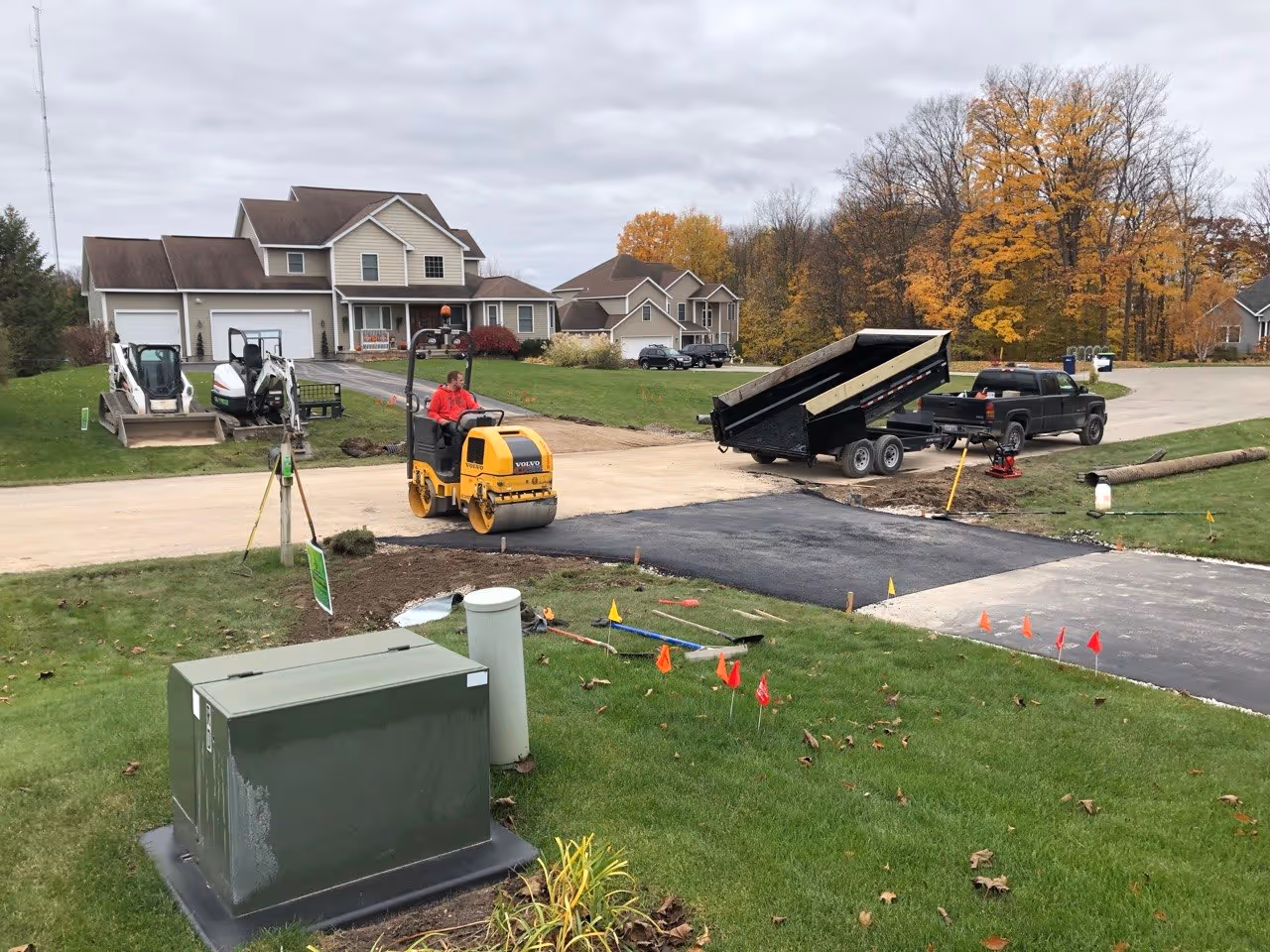 Installing and rolling professional hot-mix asphalt over a replaced culvert in South Creek, restoring the smooth transition and curb appeal of the driveway entrance.