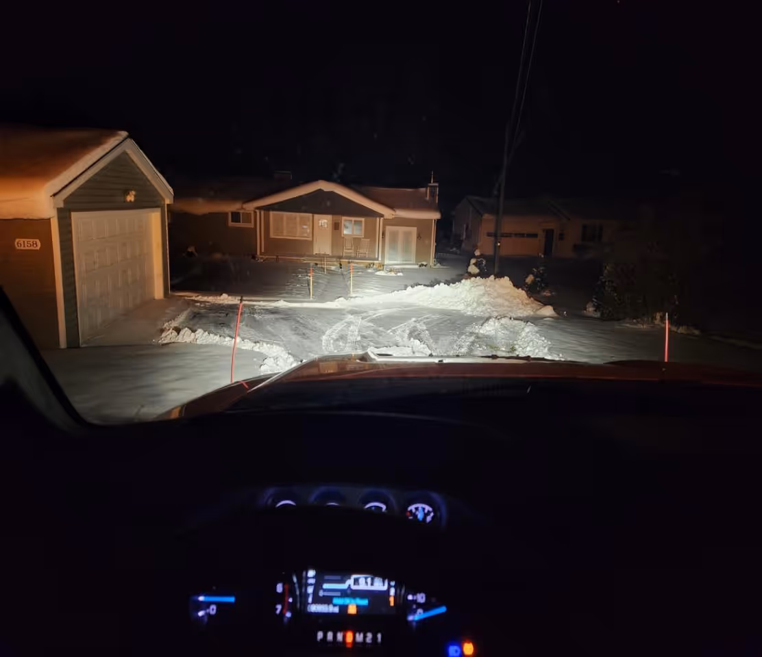 A driver’s perspective from inside a Ford F-250 snowplow truck, looking out at a perfectly cleared, freshly plowed residential driveway on Shady Shores Road in Lake Ann, Michigan. This lakefront property restoration shows the professional precision and clean finish of our snow removal services for homeowners on Lake Ann and throughout Benzie County.