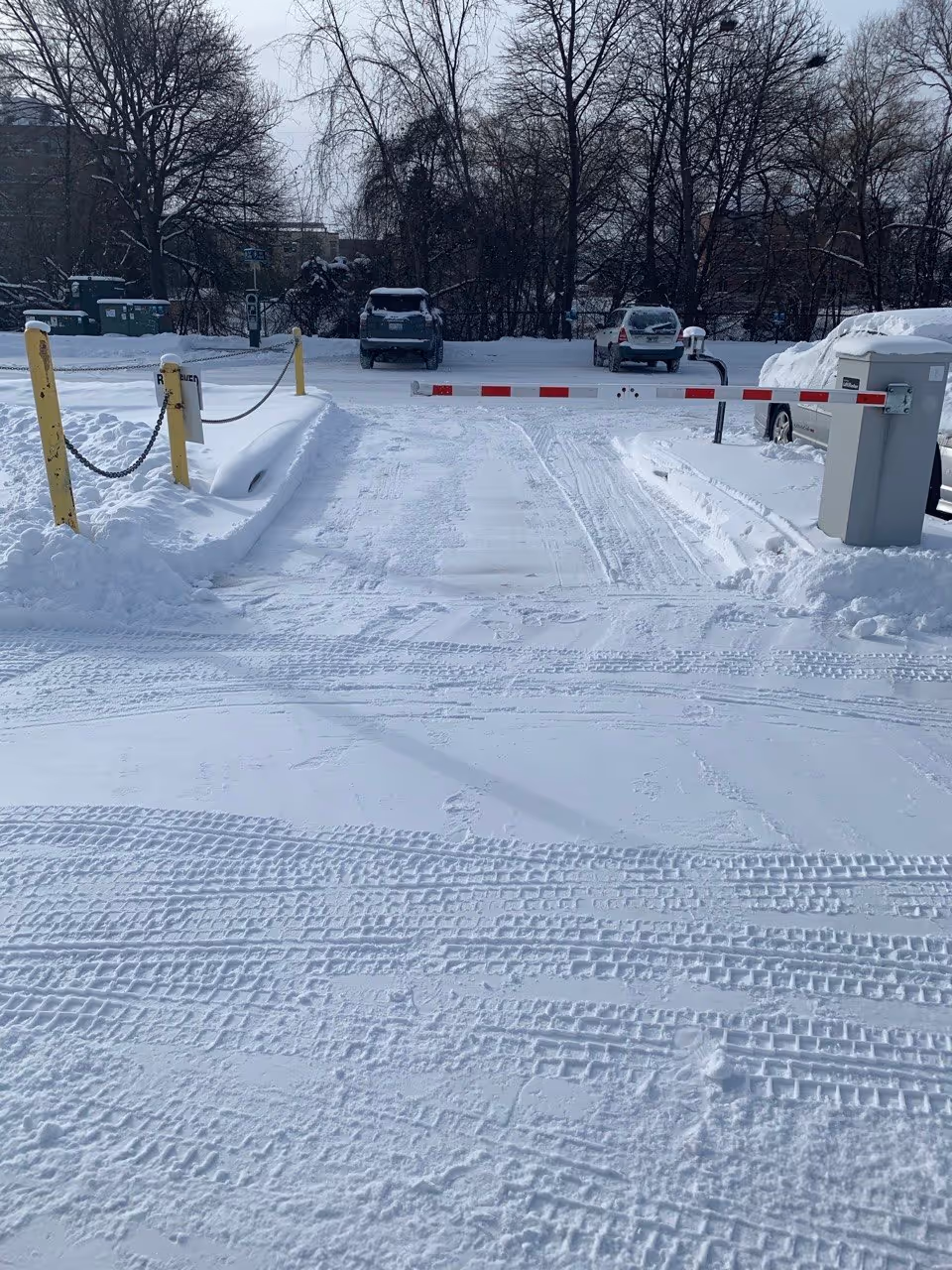 A freshly plowed and salted commercial entrance at the AT&T facility located at 941 Hastings St in Traverse City, MI. The image showcases a clear, de-iced path through a remote-controlled security gate, demonstrating professional snow removal and ice control for high-security commercial properties in Northern Michigan.