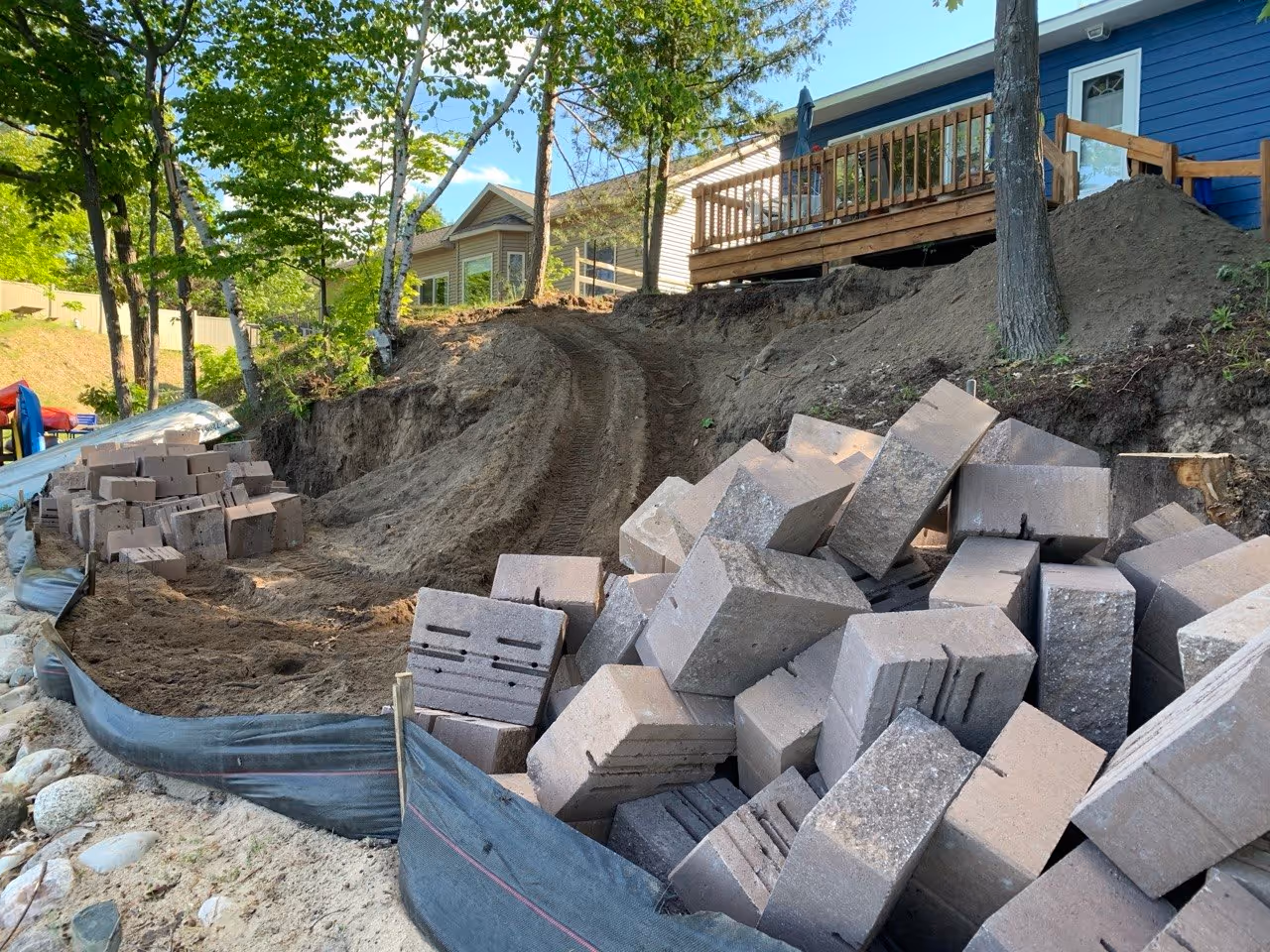 A temporary access road built down to the lake to transport heavy Versa-Lok blocks and aggregates. Proper site mobilization is key for steep projects on Van Petten Dr.
