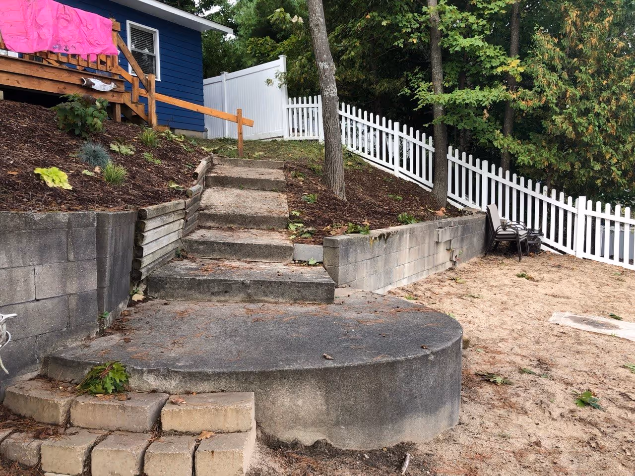 The original failed retaining wall on Silver Lake, showing significant structural collapse and soil erosion that threatened the stability of the residential lot.