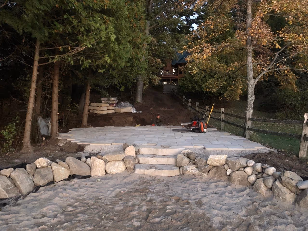 A view from the Green Lake beach looking up at the finished flagstone patio. The natural stone work creates a seamless transition between the water and the residential living area.