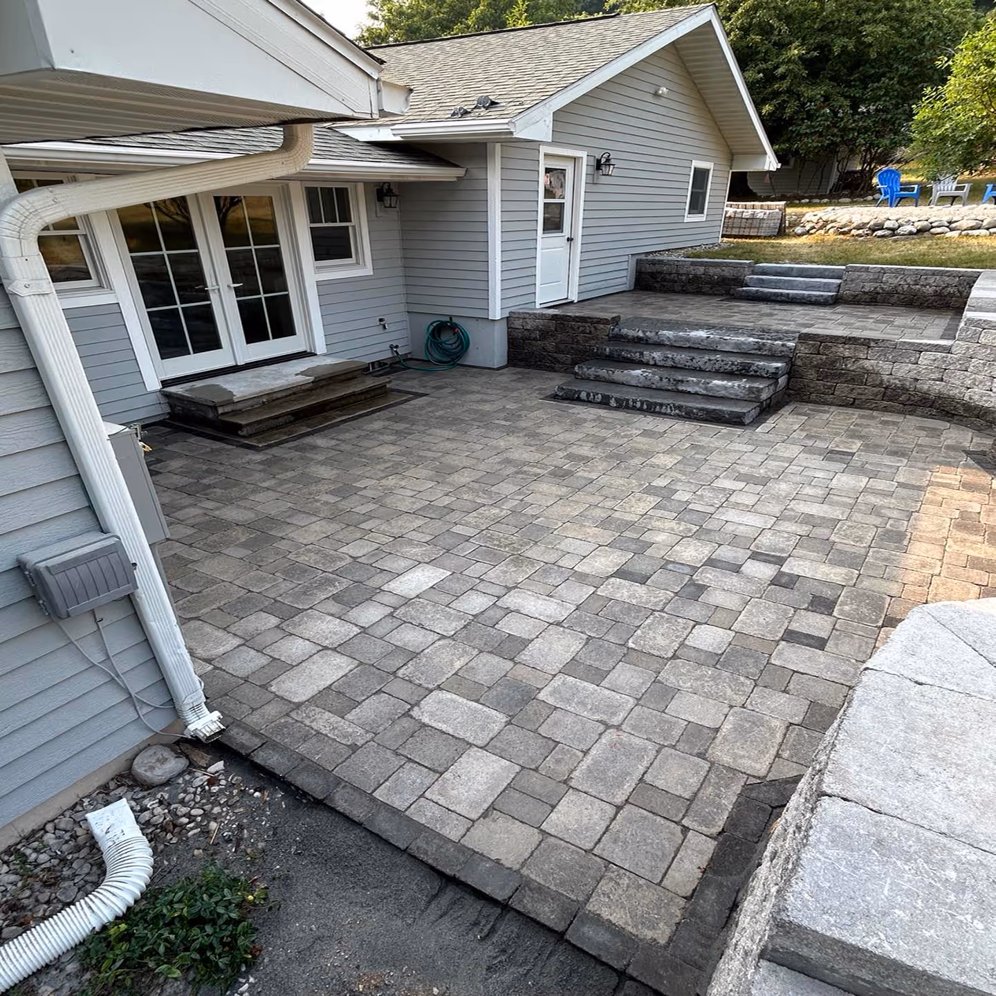 A completed paver patio in Frankfort, MI, featuring precision-cut stones and fully grouted joints using high-performance polymeric sand. The image showcases the final stabilized surface, highlighting the interlocking pattern and structural integrity provided by the newly installed retaining walls for this waterfront property in Northern Michigan.