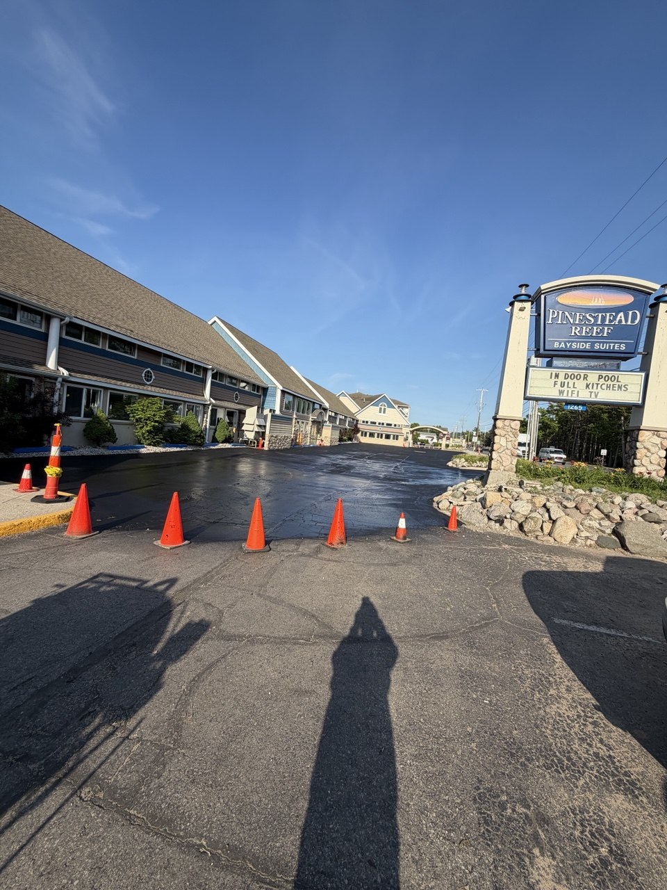 Freshly sealcoated commercial asphalt parking lot at Pinestead Reef Resort, located at 1265 US-31 in Traverse City, MI, featuring deep black pavement protection against high-traffic coastal wear.