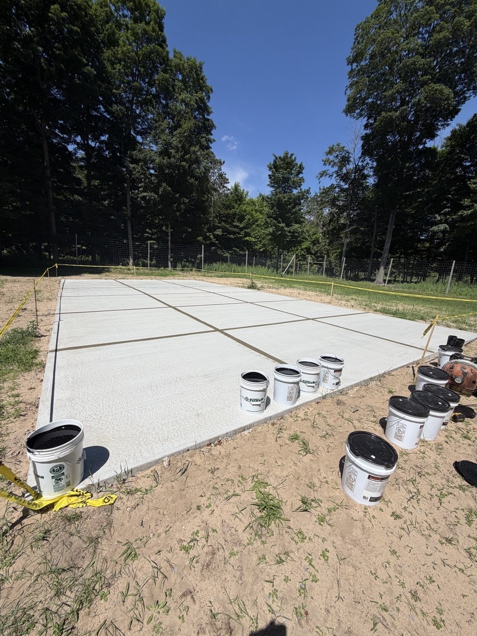 New post-tension concrete pickleball court pad with all expansion joints professionally sealed using elastomeric sealant to prevent water infiltration in Traverse City, MI.