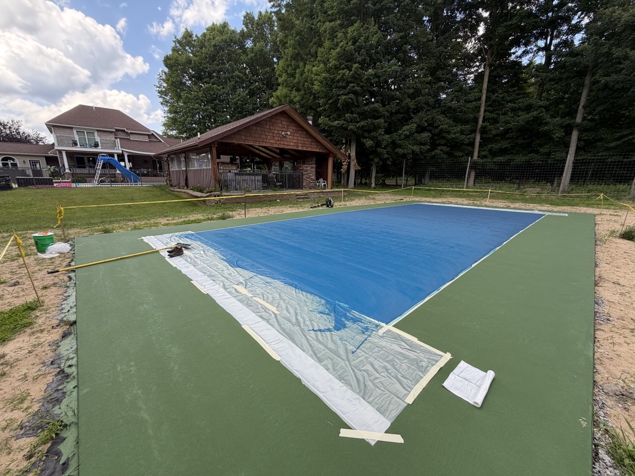 The finished second coat of high-definition blue textured acrylic color installed across the inner play area and kitchen zone of a Traverse City pickleball court.