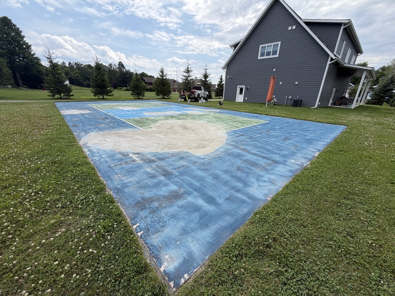 A private Torch Lake concrete pickleball court pad completely sanded, displaying smooth leveled patch repairs ready for acrylic resurfacer application.
