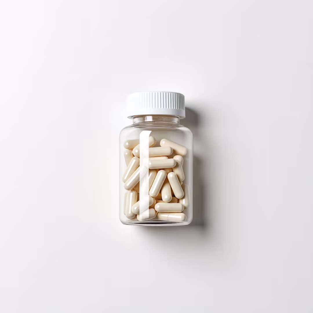 Clear plastic bottle filled with white capsules on a white background.