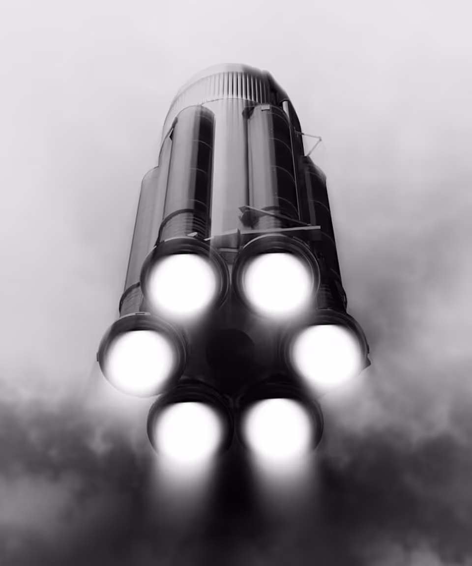 Bottom view of a rocket with five bright engines firing and smoke plumes around them during launch.