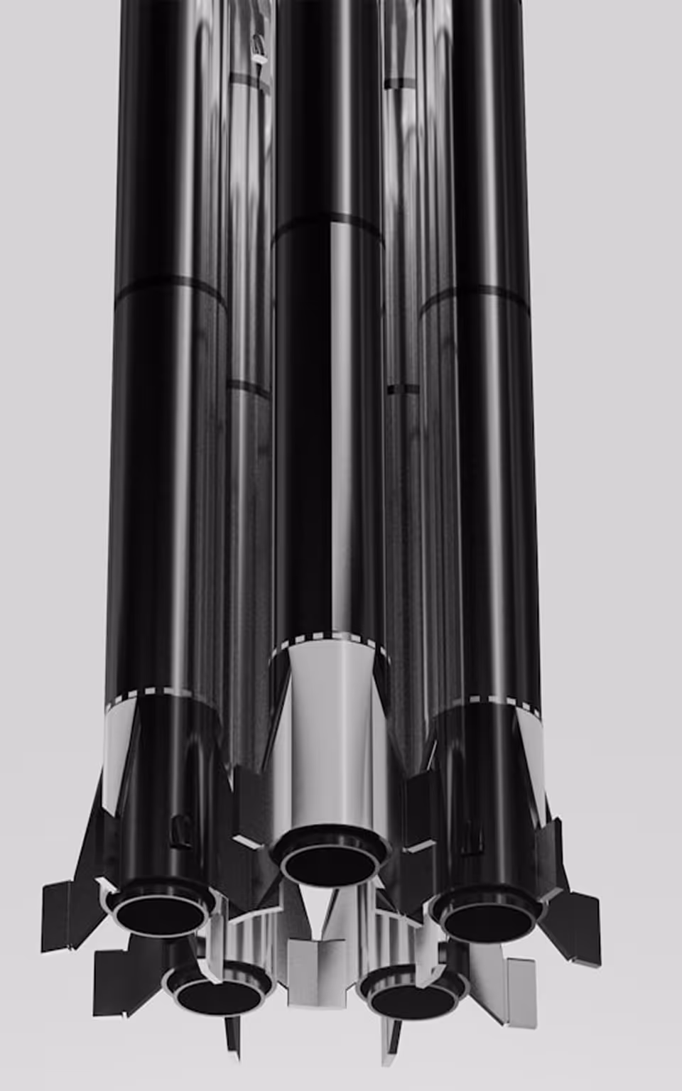 Bottom view of a cluster of cylindrical rocket boosters with fins on a gray background.