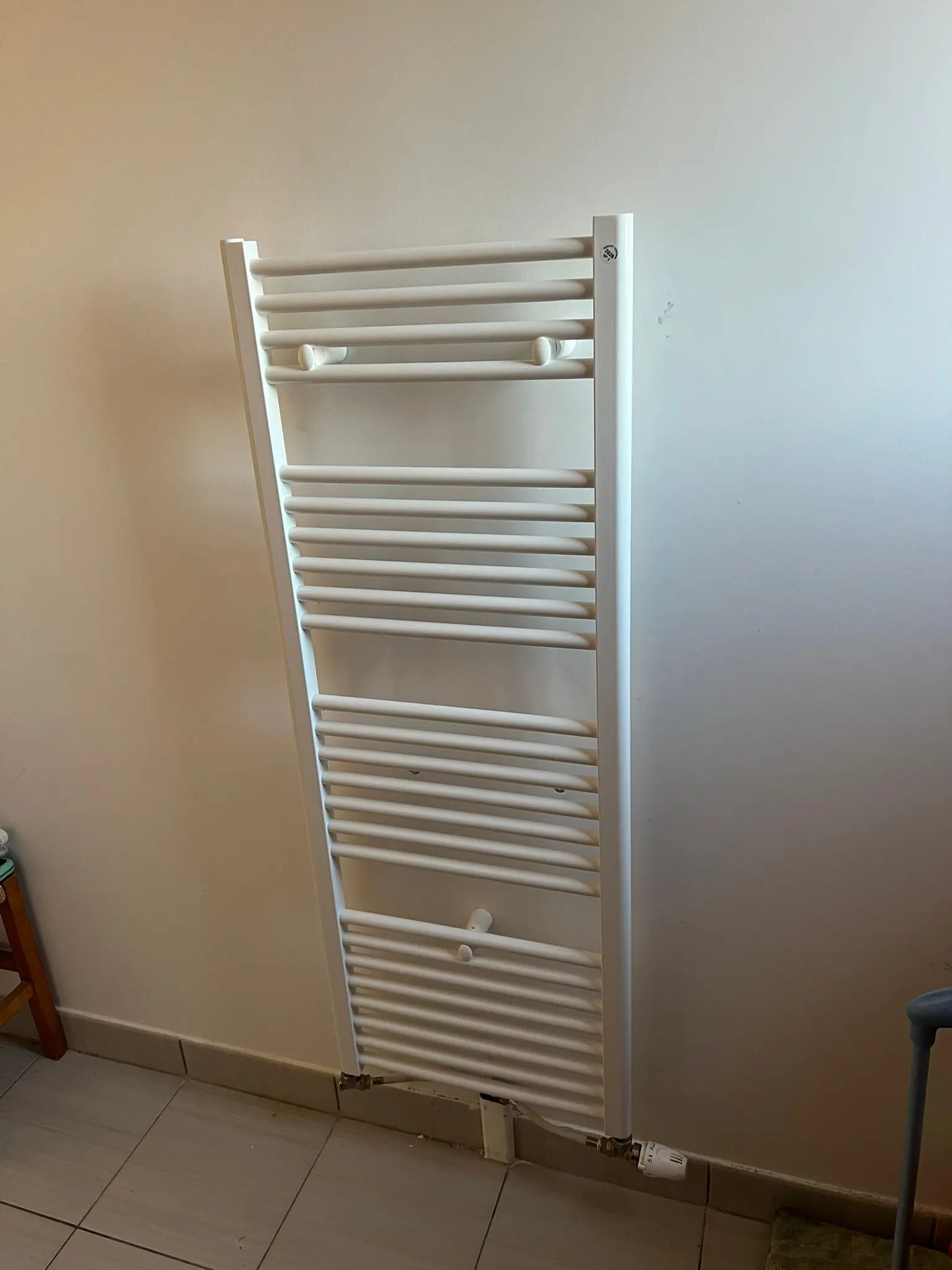 Deux lavabos blancs avec des robinets dorés posés sur un meuble-lavabo en bois, dont une porte est ouverte, et des outils disposés sur un tissu gris posé au sol.