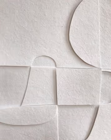 Close-up of white textured ceramic tiles with abstract geometric shapes and patterns.