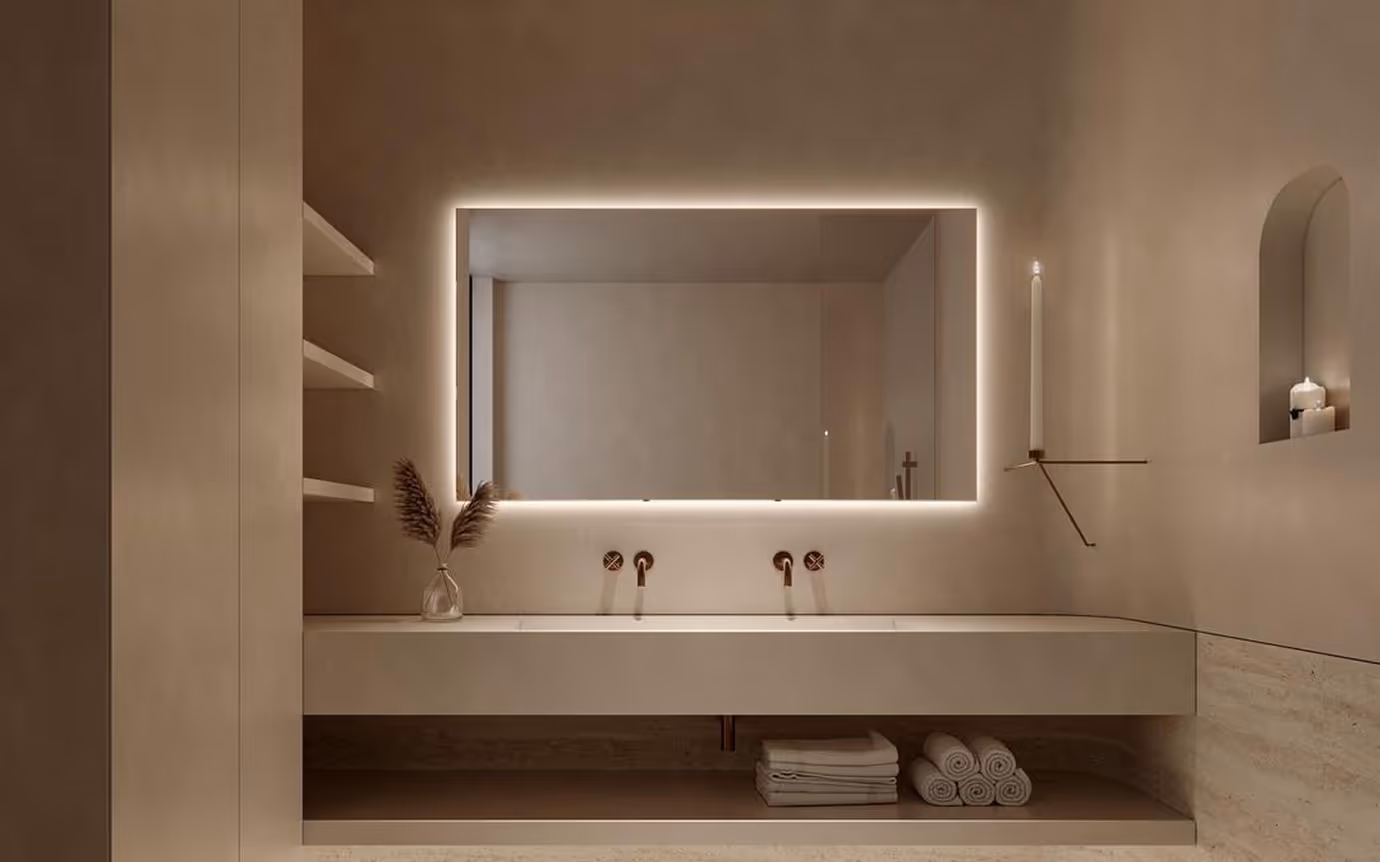 Minimalist bathroom with a large illuminated rectangular mirror, double sink, rolled towels, and candles.