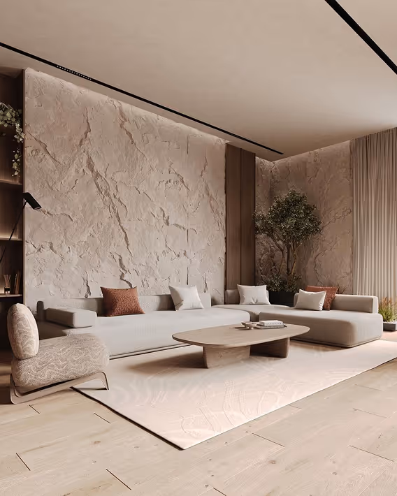 Minimalist living room with textured beige walls, light sofa, low coffee table, and a corner plant.
