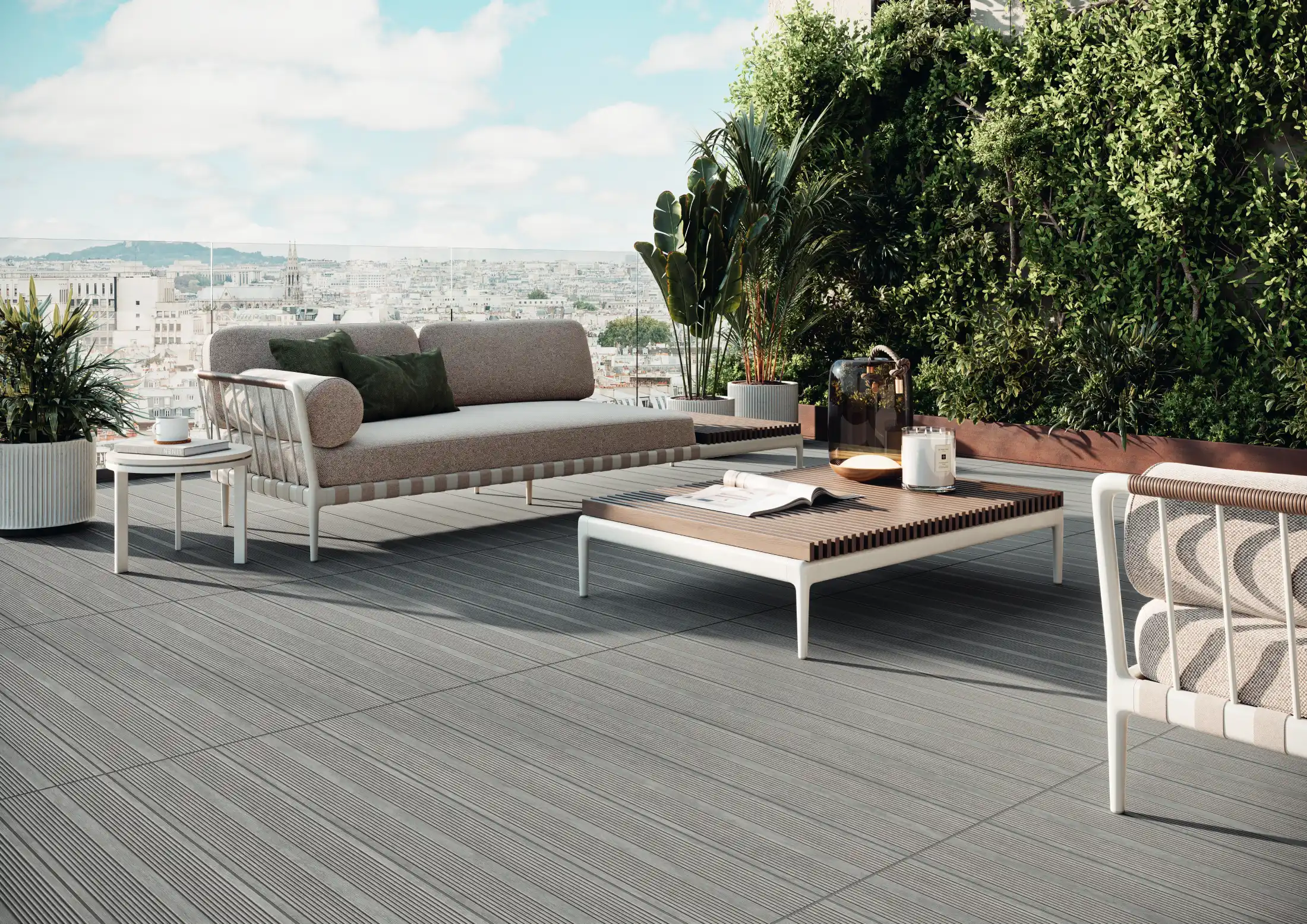 Modern outdoor seating with grey deck flooring, plants, and city skyline in the background.