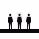 Black silhouettes of three men in suits standing on a black platform against a white background.